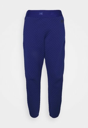 Granatowe, teksturowane spodnie dresowe Adidas Z.N.E. z elastycznym pasem i zwężanymi nogawkami, prezentowane na białym tle.