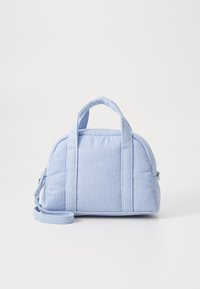 Sac à main en velours côtelé bleu clair avec deux poignées courtes, une bandoulière amovible, une forme arrondie et une texture matelassée avec des coutures visibles.
