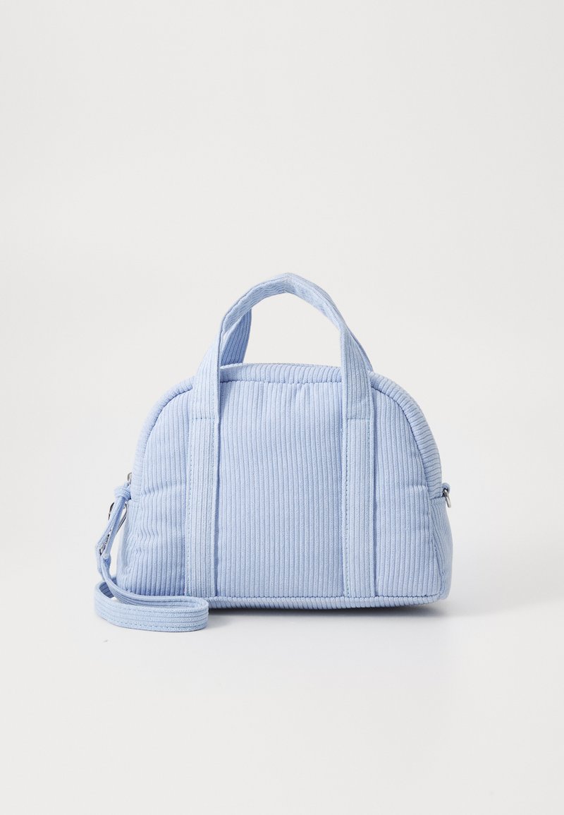 Sac à main en velours côtelé bleu clair avec deux poignées courtes, une bandoulière amovible, une forme arrondie et une texture matelassée avec des coutures visibles.