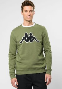 Olijfgroene sweatshirt van katoen, met een groot zwart grafisch ontwerp in het midden. Ronde halslijn en ribgebreide manchetten.