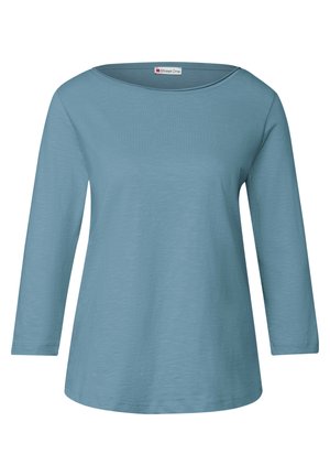 Camisa de manga larga azul claro con un escote amplio y corte recto. Fabricada con un tejido suave y texturizado. Presenta líneas simples y limpias.