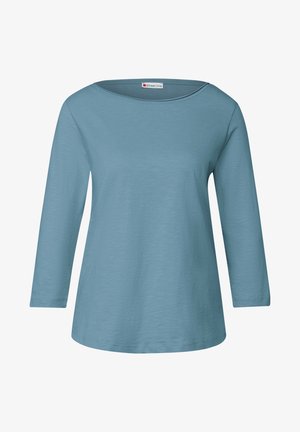 Jasnoniebieska bluzka z długim rękawem, o szerokim dekolcie i prostym kroju. Wykonana z miękkiego, teksturowanego materiału. Charakteryzuje się prostymi, czystymi liniami.
