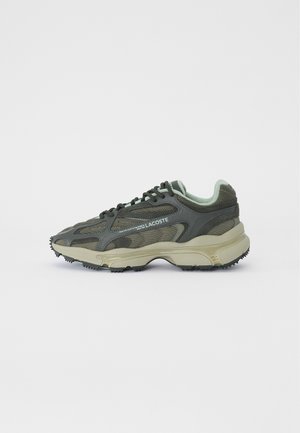 Baskets Lacoste en mesh et cuir vert foncé avec une semelle épaisse beige et des lacets noirs, vues de côté sur fond blanc.