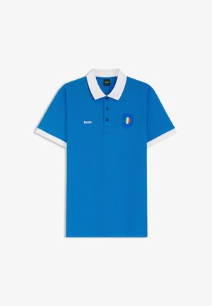 Polo blu con colletto bianco e polsini delle maniche, tre bottoni, scritta "BOSS" sul petto sinistro e toppa a scudo con la bandiera italiana sul petto destro.