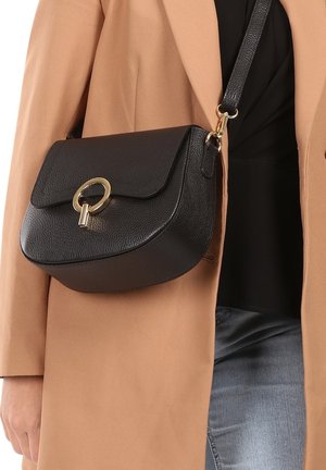 Schwarze Leder-Crossbody-Tasche mit runder Form, Klappenverschluss und goldfarbener Hardware. Texturierte Oberfläche und verstellbarer Schulterriemen.