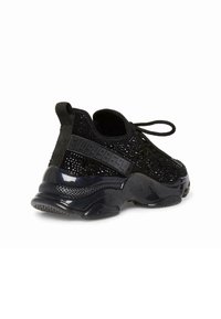 Zapatillas de punto negras con un diseño transpirable, que cuentan con una parte superior de malla texturizada, suela gruesa y brillante, y marca en relieve en el talón.