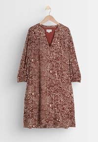 Bordeaux klänning med v-ringning, långa ärmar och intrikata krämfärgade blommönster. Tillverkad av mjukt tyg, har samlad detalj vid axlarna.