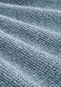 Blauwe textuurstof met een geweven patroon, met verschillende tinten blauw, die rimpelingen en golvingen over het oppervlak vertoont.