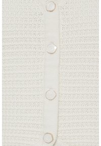 Tessuto a maglia crema con costine orizzontali strutturate e quattro bottoni simili a perle con rifinitura dorata lungo il centro.