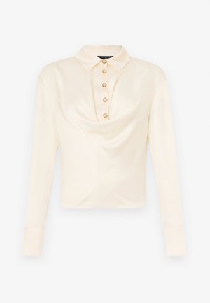 Långärmad, ljuskrämfärgad blus med krage, som har en framknäppning med sex runda, guldtonade knappar och en draperad tygdesign.
