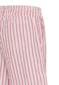 Gros plan sur un pantalon léger à rayures verticales roses et blanches avec une taille élastique, montrant le détail de la poche latérale.