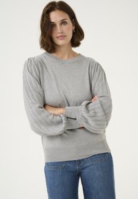 Gray pullover sweater with ribbed puff sleeves and a round neck. Soft texture, fitted body, and ribbed hem, paired with blue denim jeans.