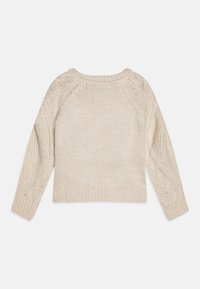 Krem strikkegenser med rund hals, lange ermer og strukturmønster på armene og kroppen. Ledig passform med ribbestrikkede mansjetter og nederkant.