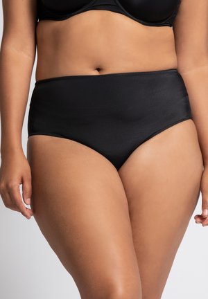 Bragas negras de tiro alto en tejido liso con diseño sin costuras y cinturilla elástica, que presentan un estilo minimalista y sin costuras visibles.