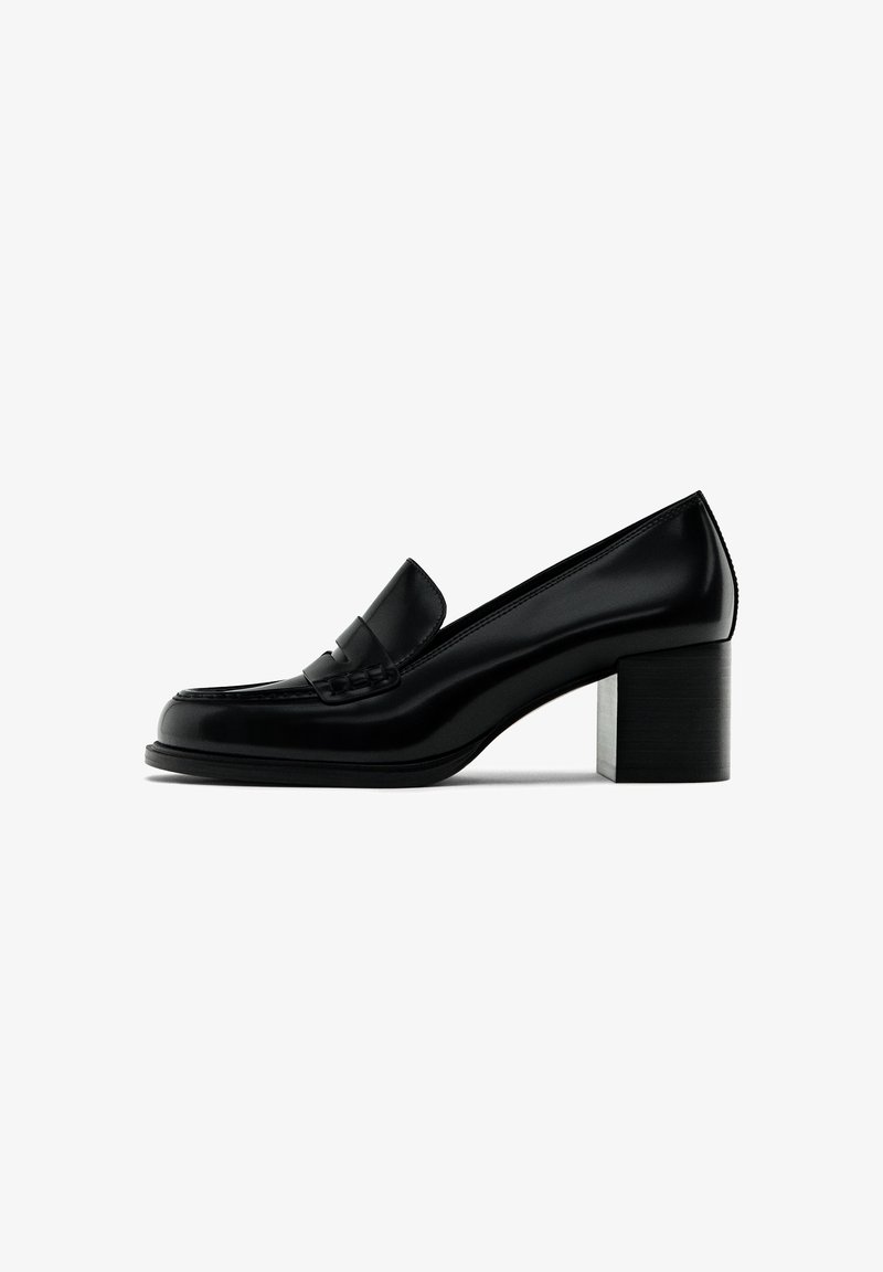 Mocassin pour femme en cuir noir avec un bout arrondi et un talon bloc épais, présenté de profil sur un fond blanc.