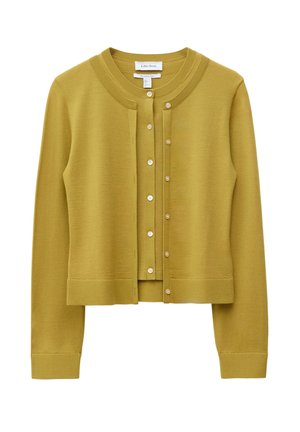 Mosterdgeel wollen vest met lange mouwen en knopen, voorzien van een geribde kraag, manchetten en onderzoom, losjes gedragen over een bijpassend mouwloos topje.