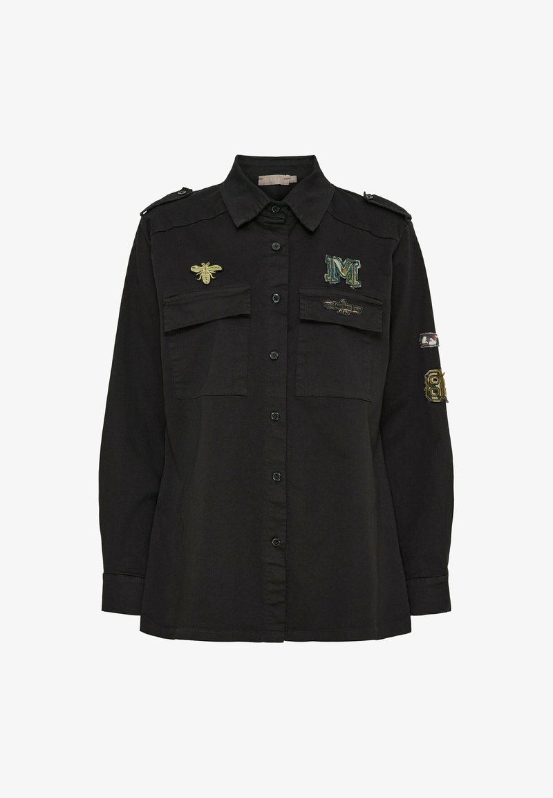 Svart skjorta med knappar har två bröstfickor, broderade bin och bokstaven 'M', samt axelremmar. Mjuk tyg, vanlig passform.