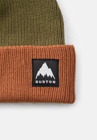 Wełniana czapka z oliwkowym wierzchem i pomarańczowym żeberkowanym mankietem. Zawiera czarną naszywkę z grafiką gór oraz napisem "BURTON".