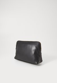 Bolsito de cuero negro con una parte frontal lisa, textura trenzada en un lado y detalles de cremallera dorada. Forma rectangular compacta.