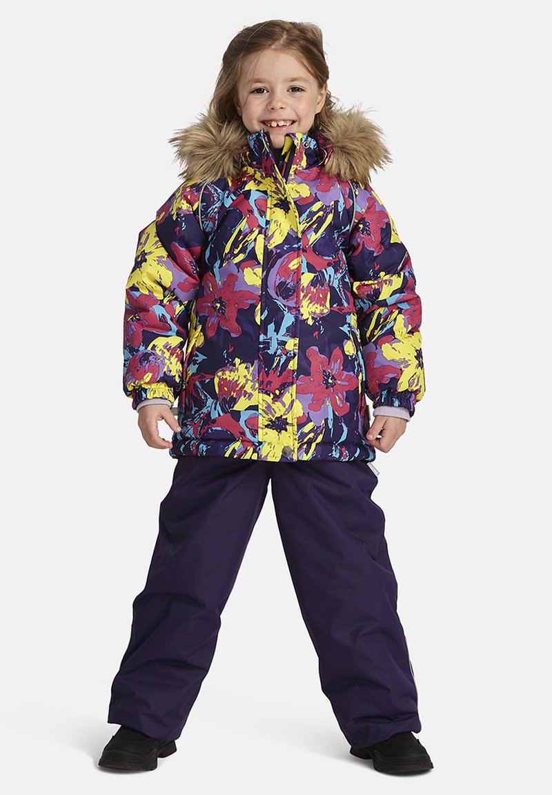 Färgglad puffjacka med blommönster i lila, gult och rött; har en foderkrage av päls. Matchas med mörklila snöbyxor och svarta stövlar.