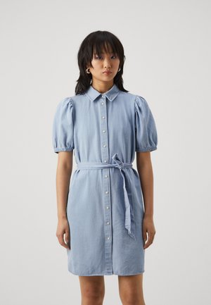 Lyseblå denimkjole med knappestolpe foran, kragehals, korte pufferm og belte i livet. Glatt tekstur med et avslappet design.