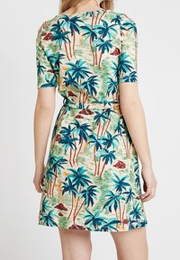 Krátké rukávy šaty z bavlny se zeleným podkladem, zdobené živým vzorem palem v modré a oranžové, stažené v pase.