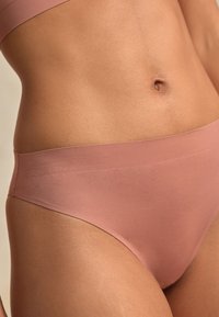 Soft, stretchy pink underwear with a low-rise design. Features a smooth texture and seamless edges for comfort and minimal visibility.