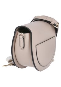 Beige syntetisk läder crossbody-väska med svarta detaljer, rund form, justerbar rem och en framficka. Guldiga metallaccenter.