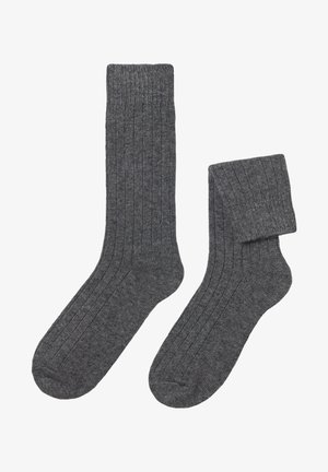 Chaussettes côtelées gris foncé avec une texture visible, dotées d'une longueur standard et de poignets élastiqués pour un maintien sûr.