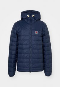 Námornícky modrá prešívaná bunda s kapucňou, ktorá má horizontálny prešívaný dizajn, predné zapínanie na zips a nášivku s logom na hrudi.