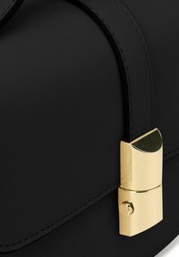 Schwarze Lederhandtasche mit glatter Textur, ausgestattet mit einem goldfarbigen Verschluss und eleganten Nahtakzenten. Geometrische Form mit klaren Linien.