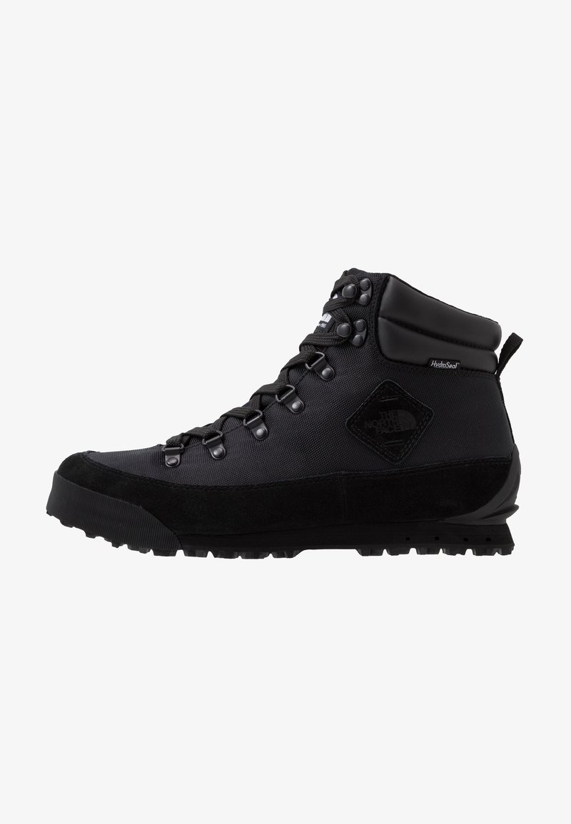 Botte de randonnée noire de hauteur moyenne avec une semelle robuste, des œillets métalliques pour les lacets, un col rembourré et une étiquette HydroSeal imperméable sur le côté.