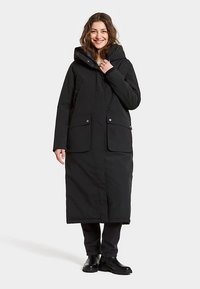 Zwarte lange parka met capuchon, voorzien van twee steekzakken aan de voorkant en een rechte snit. Gemaakt van glad, weerbestendig materiaal.