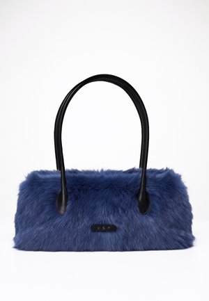 Sac à main en fausse fourrure bleue avec des poignées en cuir noir et une petite étiquette noire avec les lettres dorées VSP sur le devant.