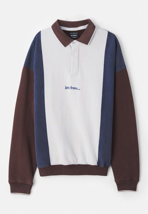 Sweter polo w białym kolorze z granatowymi i bordowymi panelami, z długimi rękawami oraz haftowanym napisem "iets frans..." na piersi.