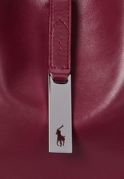 Wine-colored leather handbag with a smooth texture, featuring a silver hardware clasp and an embossed logo of a rearing horse.