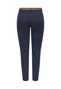 Pantalon bleu marine fuselé avec deux poches passepoilées à l’arrière et une ceinture tressée marron clair sur fond blanc.