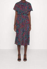 Blommig paisleymönstrad klänning med krage och knappar, korta ärmar och en A-linjeformad kjol. Har ett knytbälte och färgstarka detaljer.