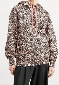 Czarna bluza z kapturem w różowo-białe plamki. Posiada kieszeń kangurkę oraz ściągacze przy mankietach. Kapturek z ściągaczem w różowych akcentach.