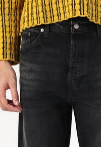 Sorte denim jeans med slim fit, der har fem lommer, en metalknap og lynlås, samt en glat tekstur. Livremmen er ensfarvet.