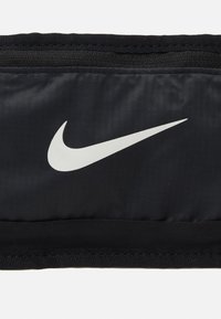 Banda negra de Nike hecha de tela suave, con un gran logotipo de swoosh blanco de Nike. Incluye una banda elástica para un ajuste seguro.