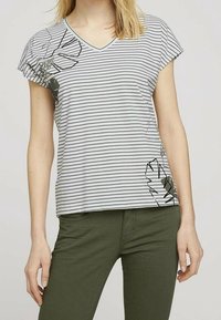 Camiseta de cuello en V de manga corta con rayas horizontales en gris y blanco; presenta un diseño gráfico en verde oscuro en el lado izquierdo.