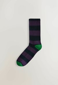 Zwarte en donkerpaarse gestreepte sok met een groene teen en hiel. Ribbelstructuur, lengte tot midden van de kuit en kleurrijke contrasterende details.