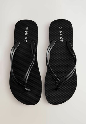 Černé žabky s texturovanou podrážkou a tenkými popruhy. Na stélce jsou značky "NEXT" a velikosti. Jednoduchý, plochý design.
