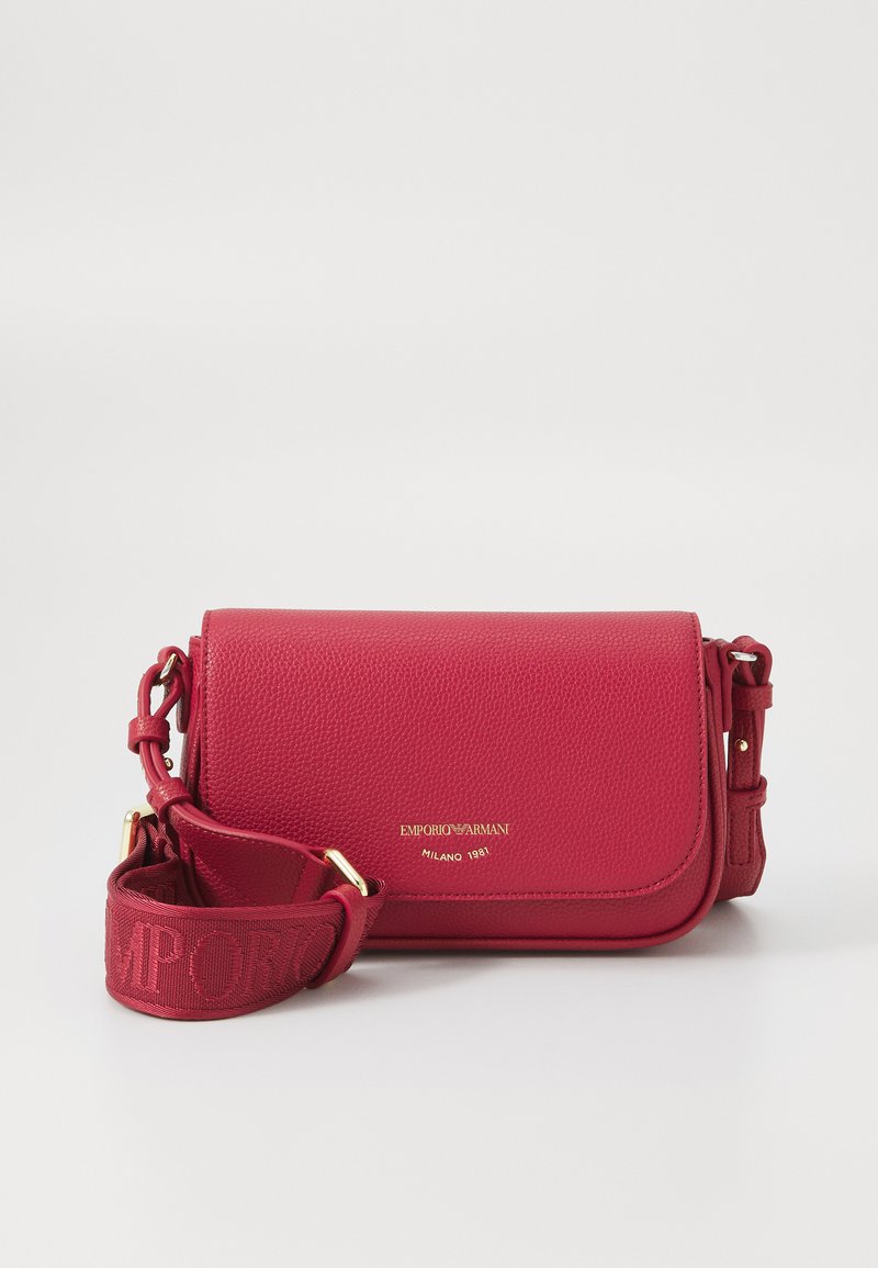 Borsa a tracolla in pelle rossa con finitura testurizzata, dettagli del logo dorato e una tracolla in tessuto con il nome del marchio. Forma compatta e rettangolare.