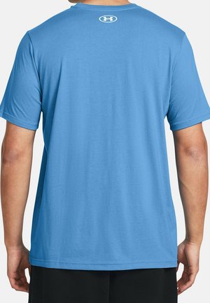 Man die een lichtblauw Under Armour T-shirt met korte mouwen draagt, gezien van achteren, gecombineerd met zwarte shorts.