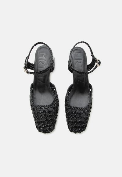 Mustad punutud nahast avatud kandadega sandaalid ruudukujuliste varvaste ja reguleeritavate punutud pahkluu rihmadega, vaadatuna ülevalt.