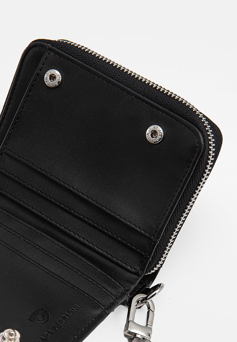 Portafoglio nero con chiusura a zip, dotato di più scomparti per carte, hardware argentato, texture liscia e un logo distintivo stampato all'interno.