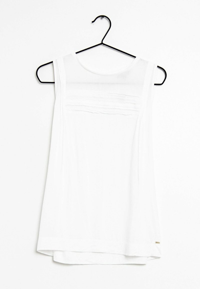 Top blanco sin mangas hecho de una tela ligera, con una textura suave, escote redondeado y un sutil detalle bordado en el pecho.