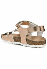 Metalen rosegouden sandaal met uitsnijdingen, verstelbare strap en een geprofileerde kurken voetbed. Witte, geribbelde rubberen zool voor grip.